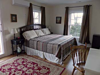 king bed, red oriental rug, 2 windows